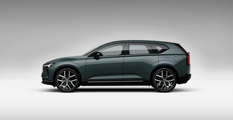 Green Volvo EX60 car left facing with grey shadow background