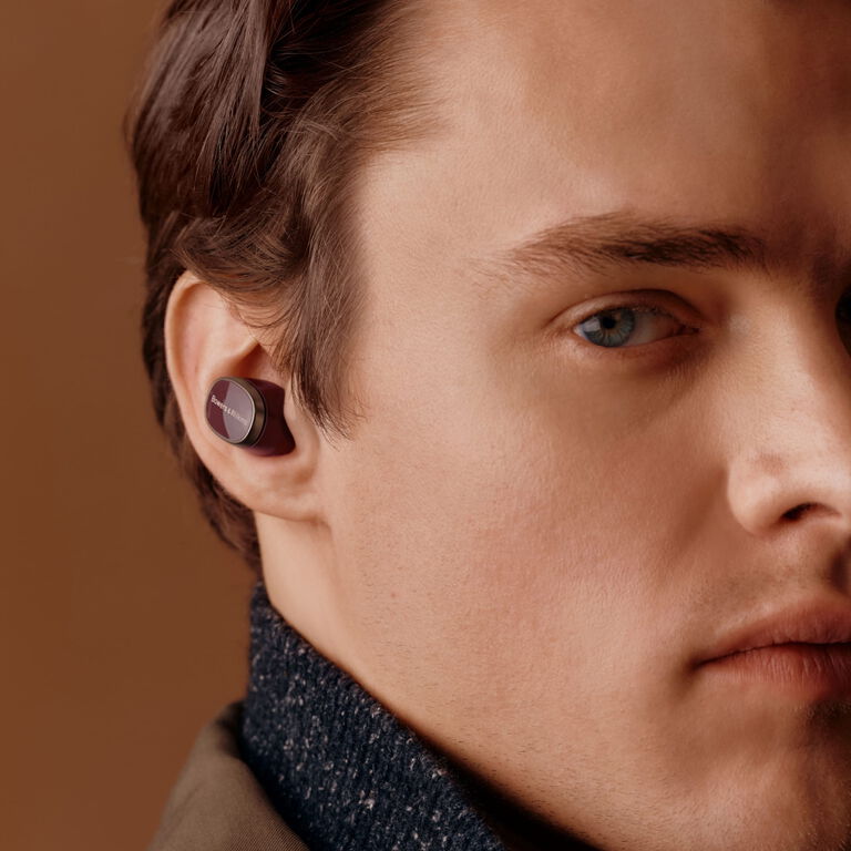 Hear the playlist - man facing right wearing in ear wireless earbuds with a ballcap on
